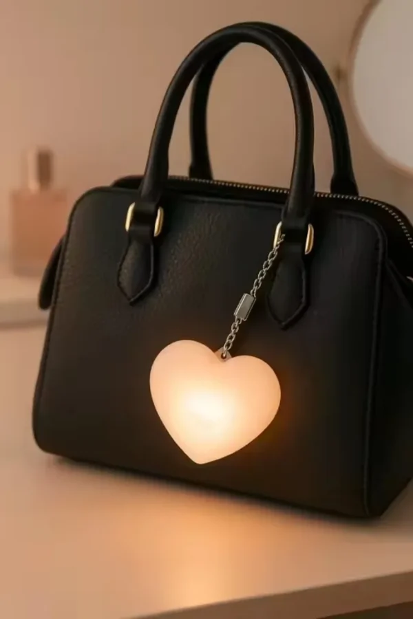 heart led keychain light glowing on handbag
